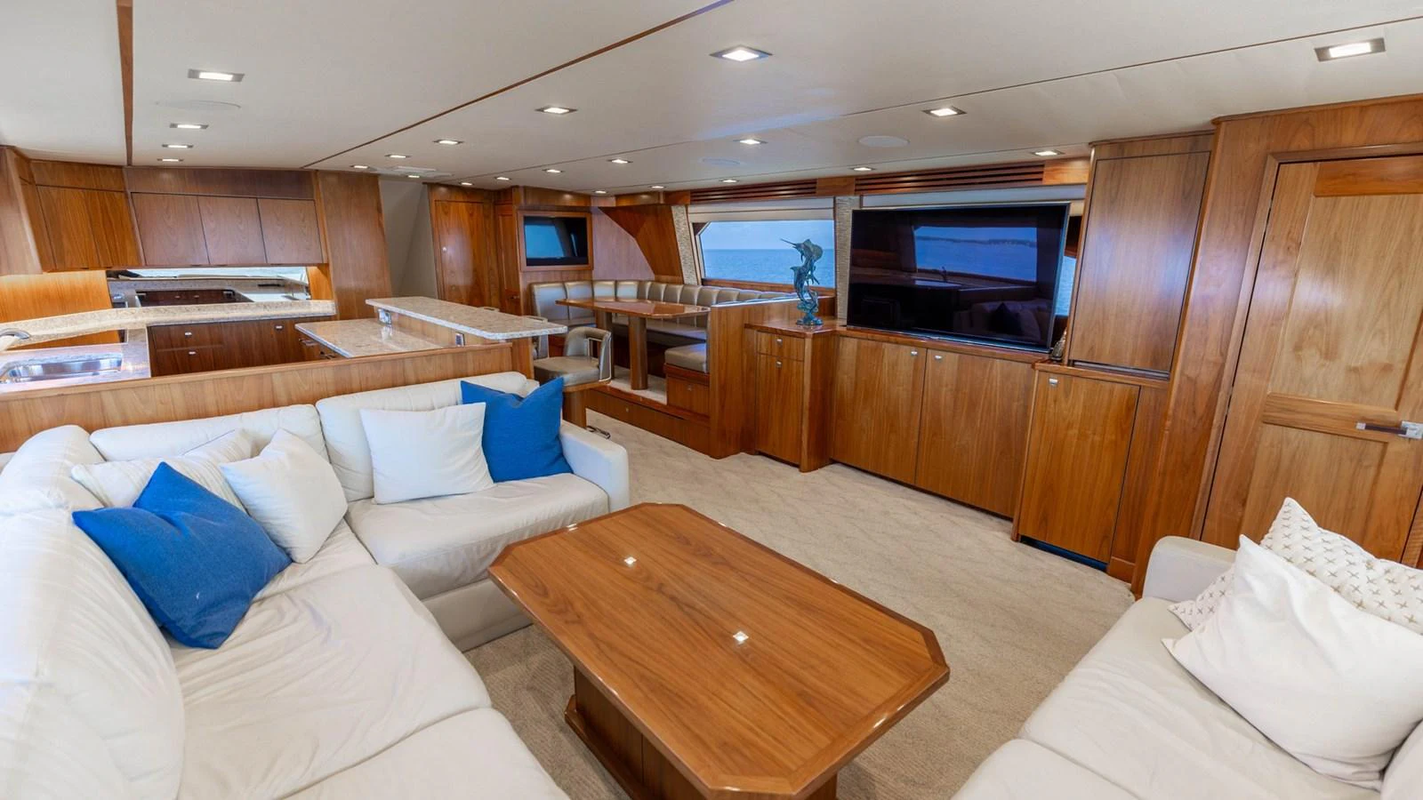 The salon features plush seating, warm wooden finishes, and ample natural light for a cozy and inviting atmosphere. aboard CE Yacht for Sale