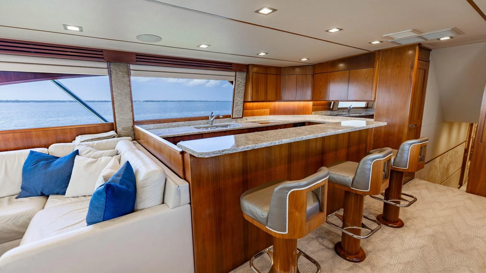 The yacht's galley features a luxurious bar area with comfortable seating and a stunning view of the water. aboard CE Yacht for Sale