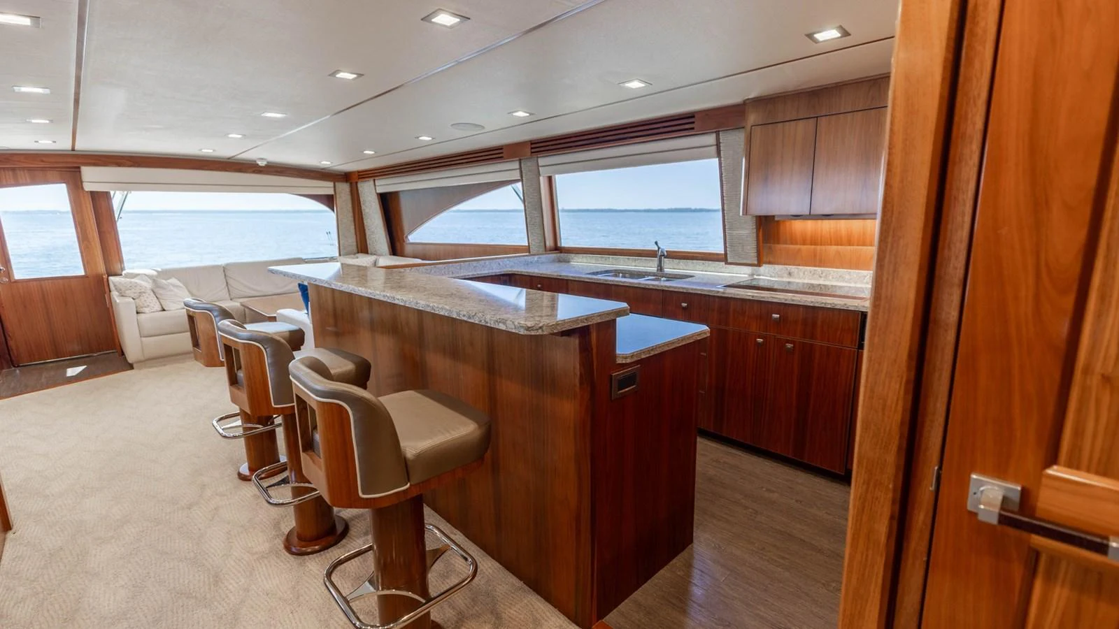 The yacht's galley features a sleek bar area with comfortable seating and expansive windows offering stunning sea views. aboard CE Yacht for Sale