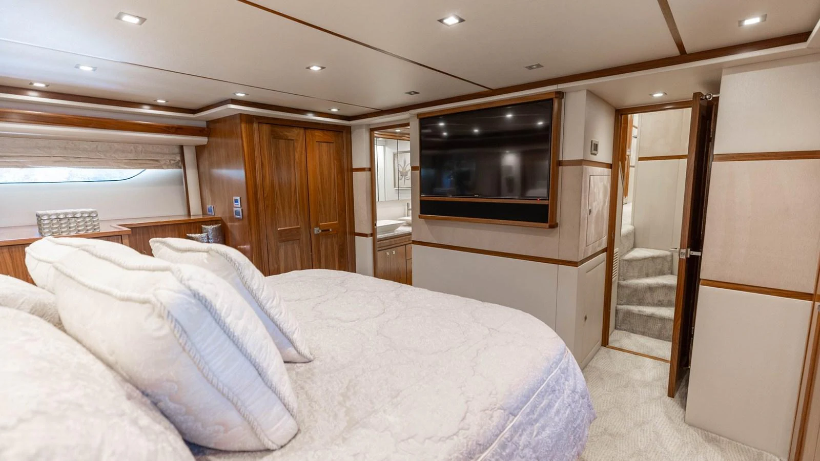The master stateroom features a luxurious bed, ample storage, and a large flat-screen TV. aboard CE Yacht for Sale