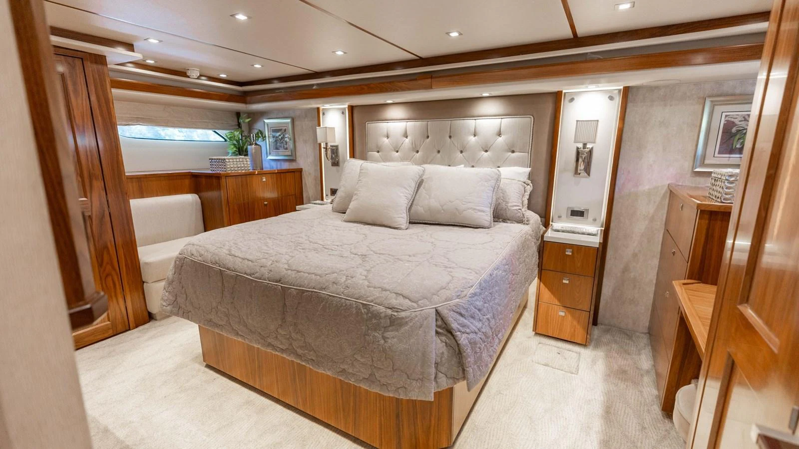 The master stateroom features a luxurious bed with elegant wood finishes and ample lighting. aboard CE Yacht for Sale