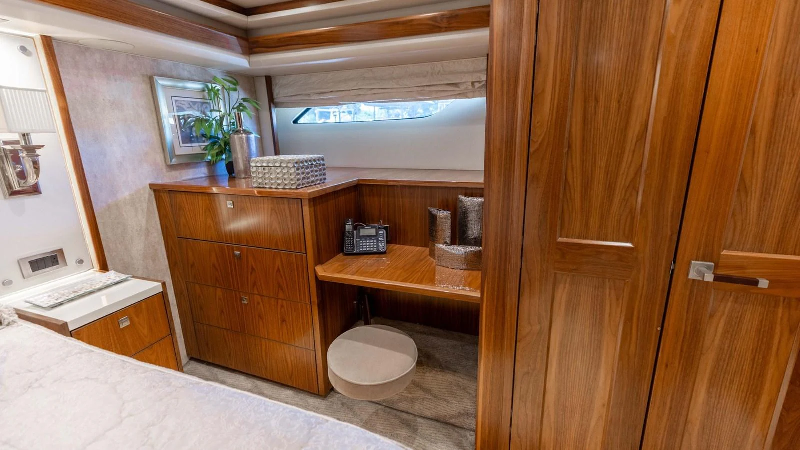 The stateroom features elegant wood cabinetry and a cozy workspace with a view. aboard CE Yacht for Sale