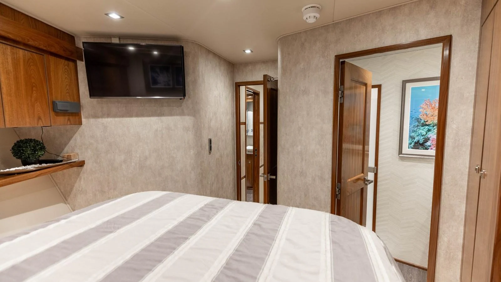 A cozy yacht stateroom featuring a comfortable bed and modern amenities. aboard CE Yacht for Sale