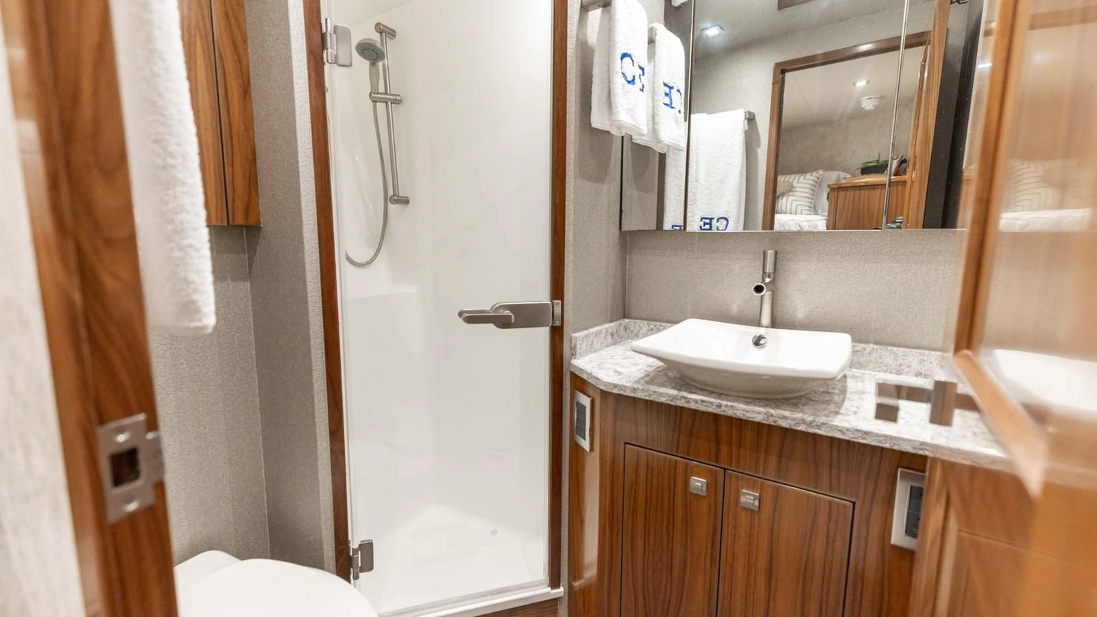A modern yacht bathroom featuring a sleek shower and elegant wooden cabinetry. aboard CE Yacht for Sale