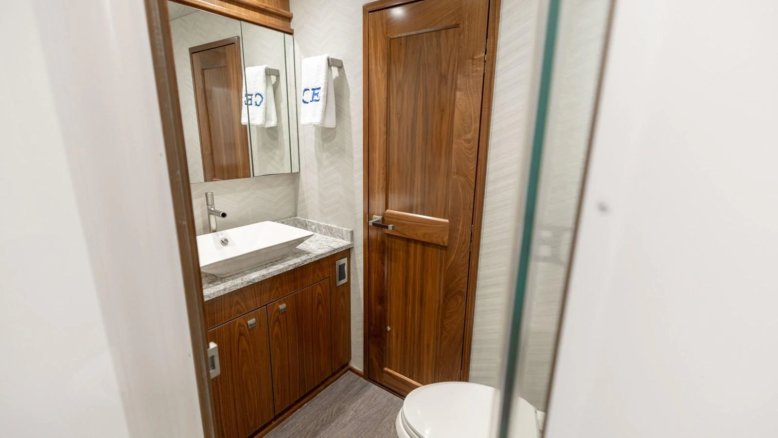 The yacht's bathroom features elegant wooden cabinetry and modern fixtures. aboard CE Yacht for Sale