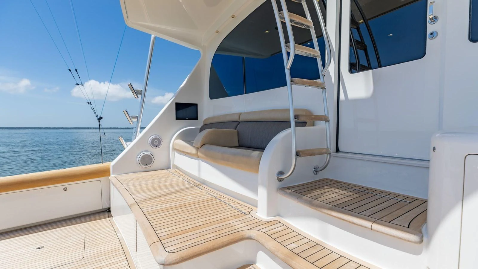 The aft deck features comfortable seating and a sleek staircase leading to the upper deck. aboard CE Yacht for Sale