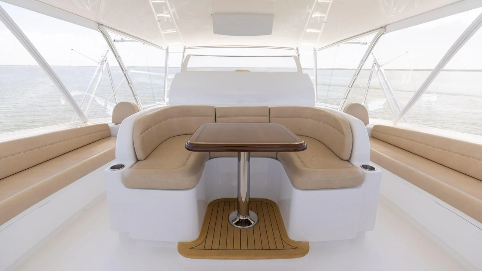 The yacht's salon features a spacious seating area with a central table, offering panoramic views through large windows. aboard CE Yacht for Sale