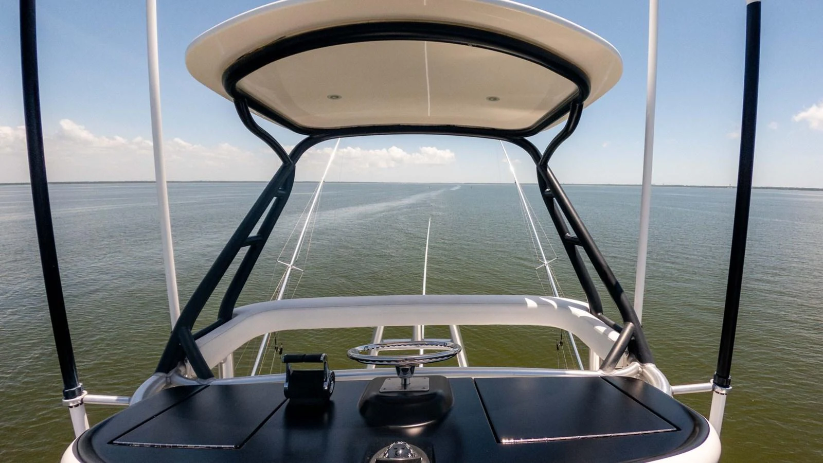 The yacht's helm offers a commanding view over calm waters, framed by a sleek, modern canopy. aboard CE Yacht for Sale