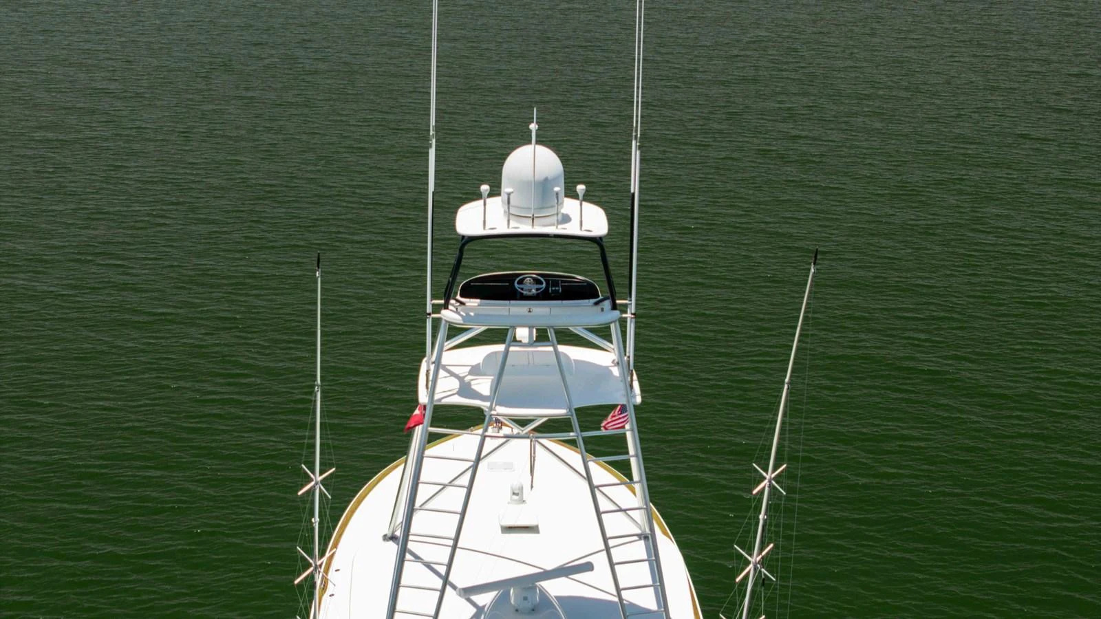 The yacht's upper structure and antennas are prominently displayed against a serene water backdrop. aboard CE Yacht for Sale