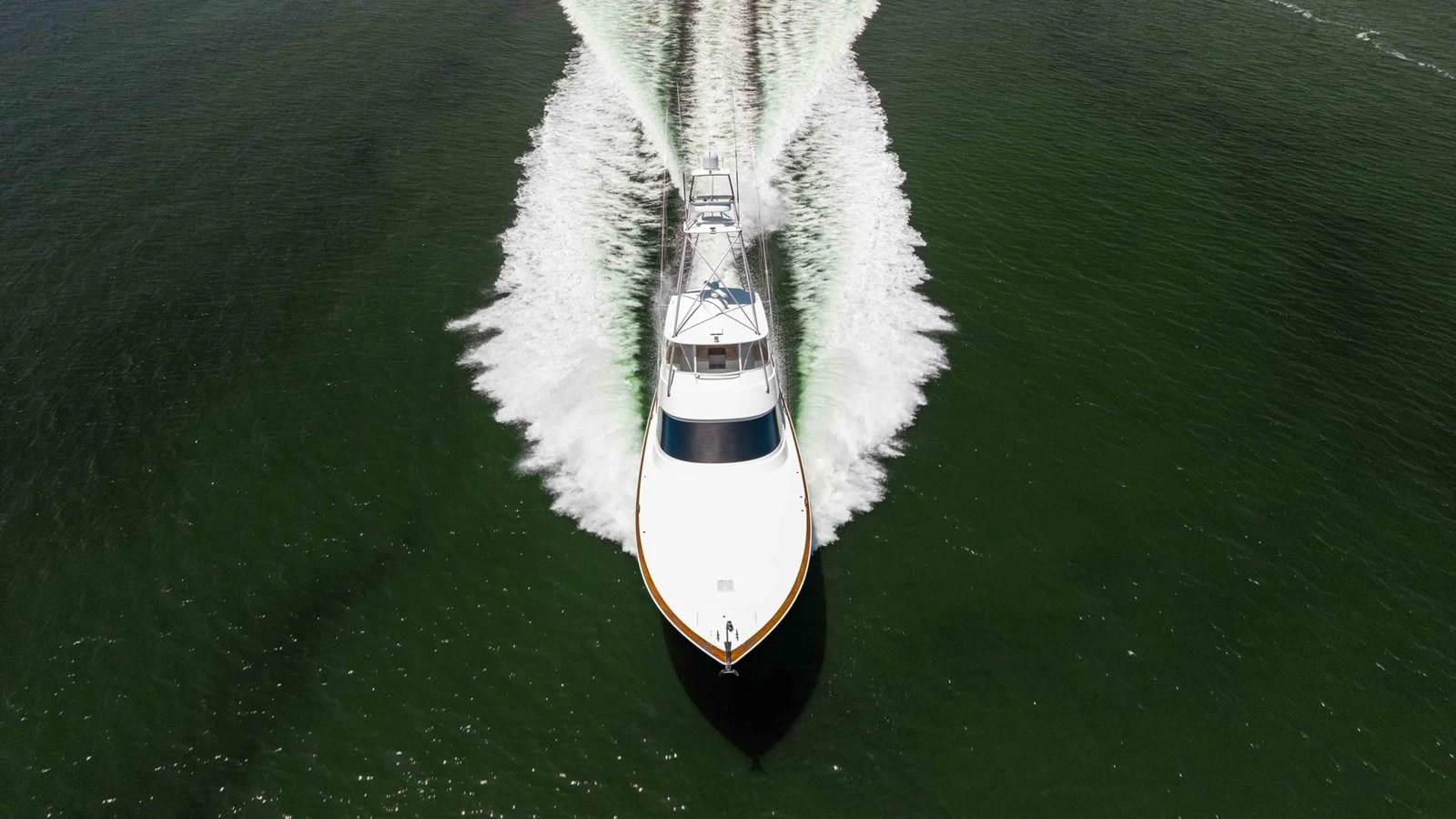 A sleek yacht cruises swiftly through the water, leaving a dynamic wake behind. aboard CE Yacht for Sale