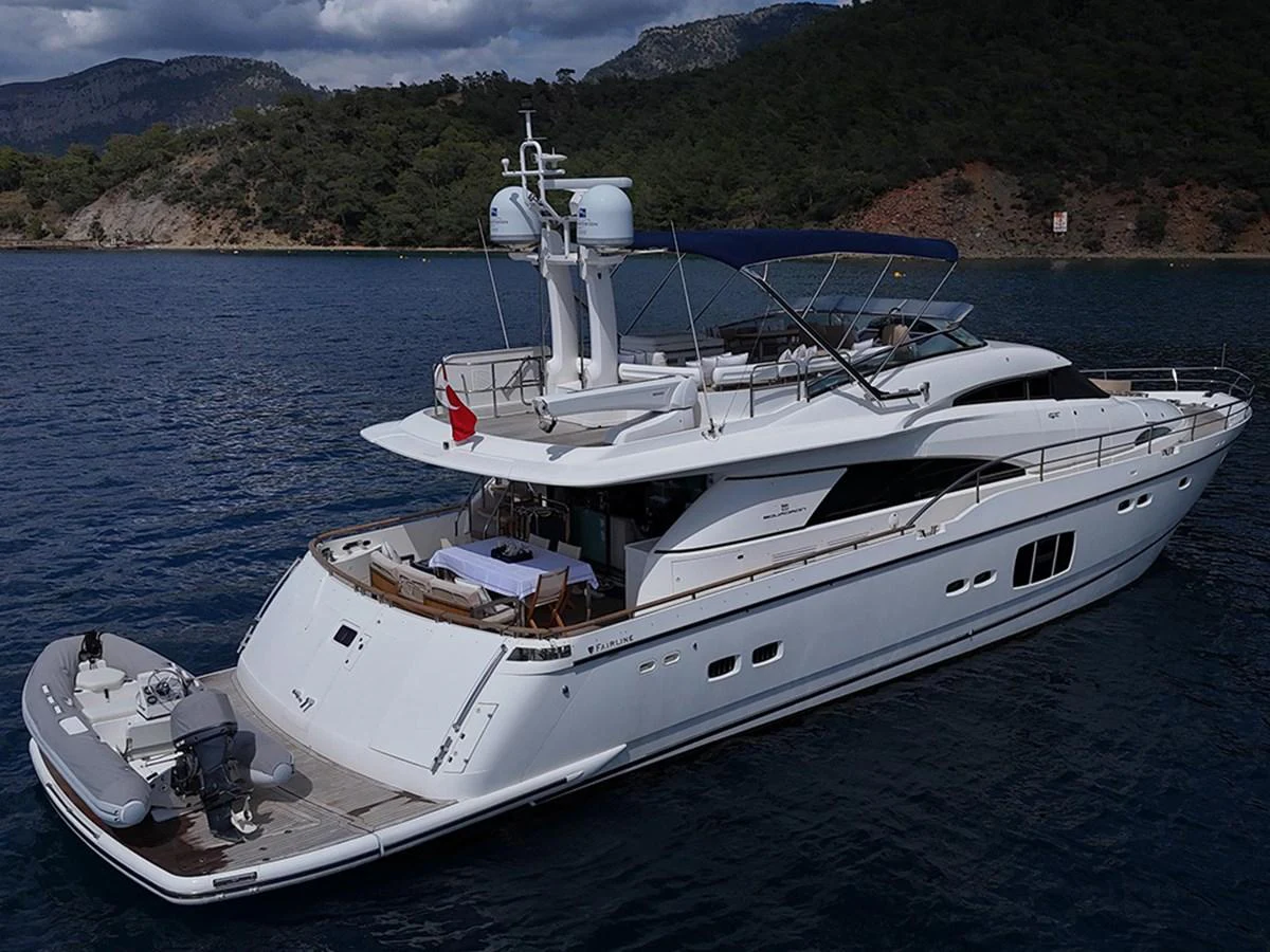 A sleek and modern yacht cruising in a serene coastal setting. aboard SEDEF Yacht for Sale