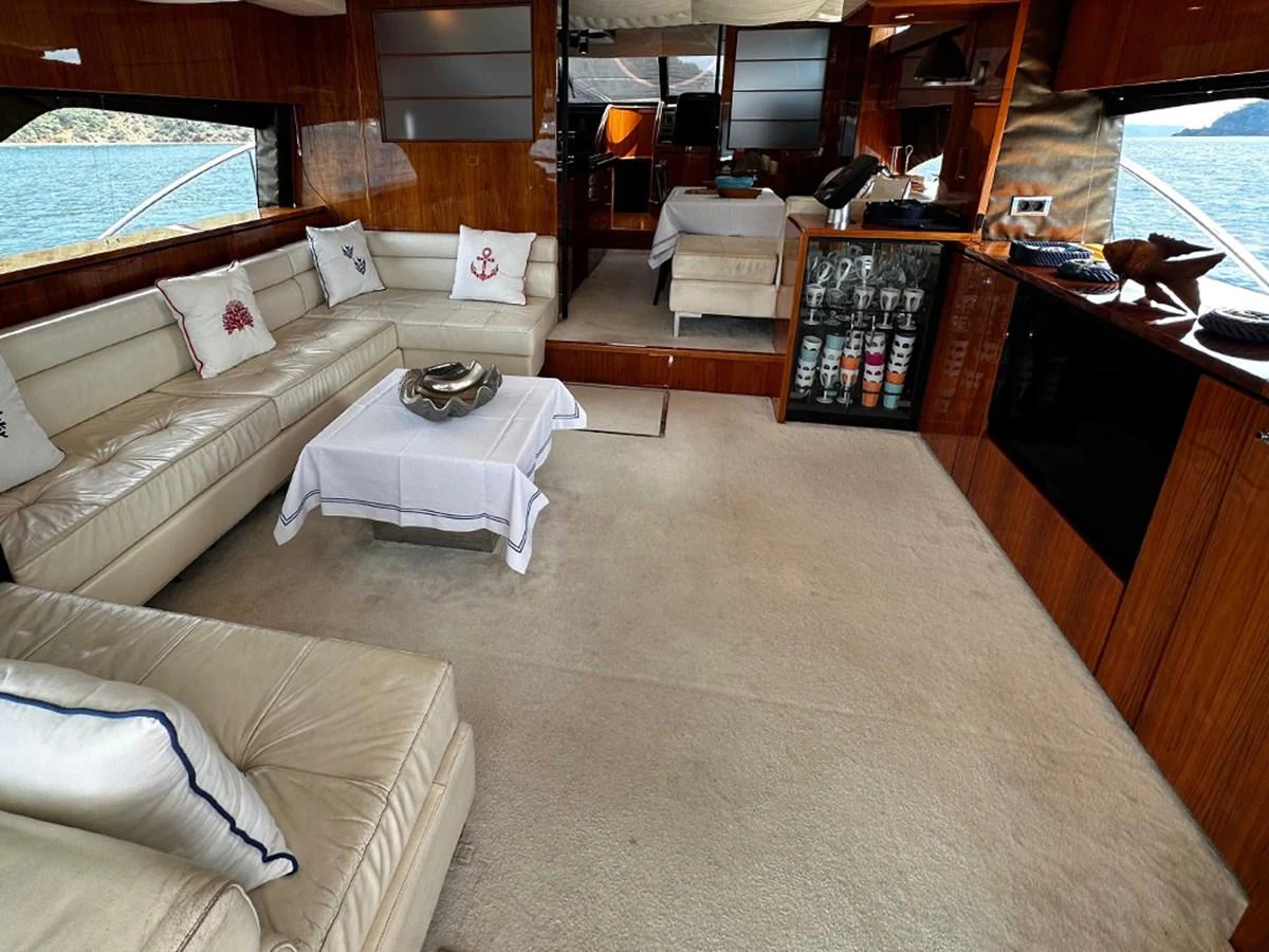 The salon features plush seating, a coffee table, and large windows offering scenic views. aboard SEDEF Yacht for Sale