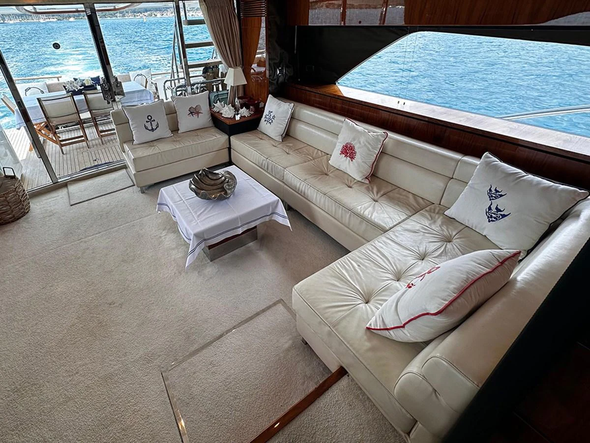 The salon features a comfortable seating area with a view of the water through large windows. aboard SEDEF Yacht for Sale