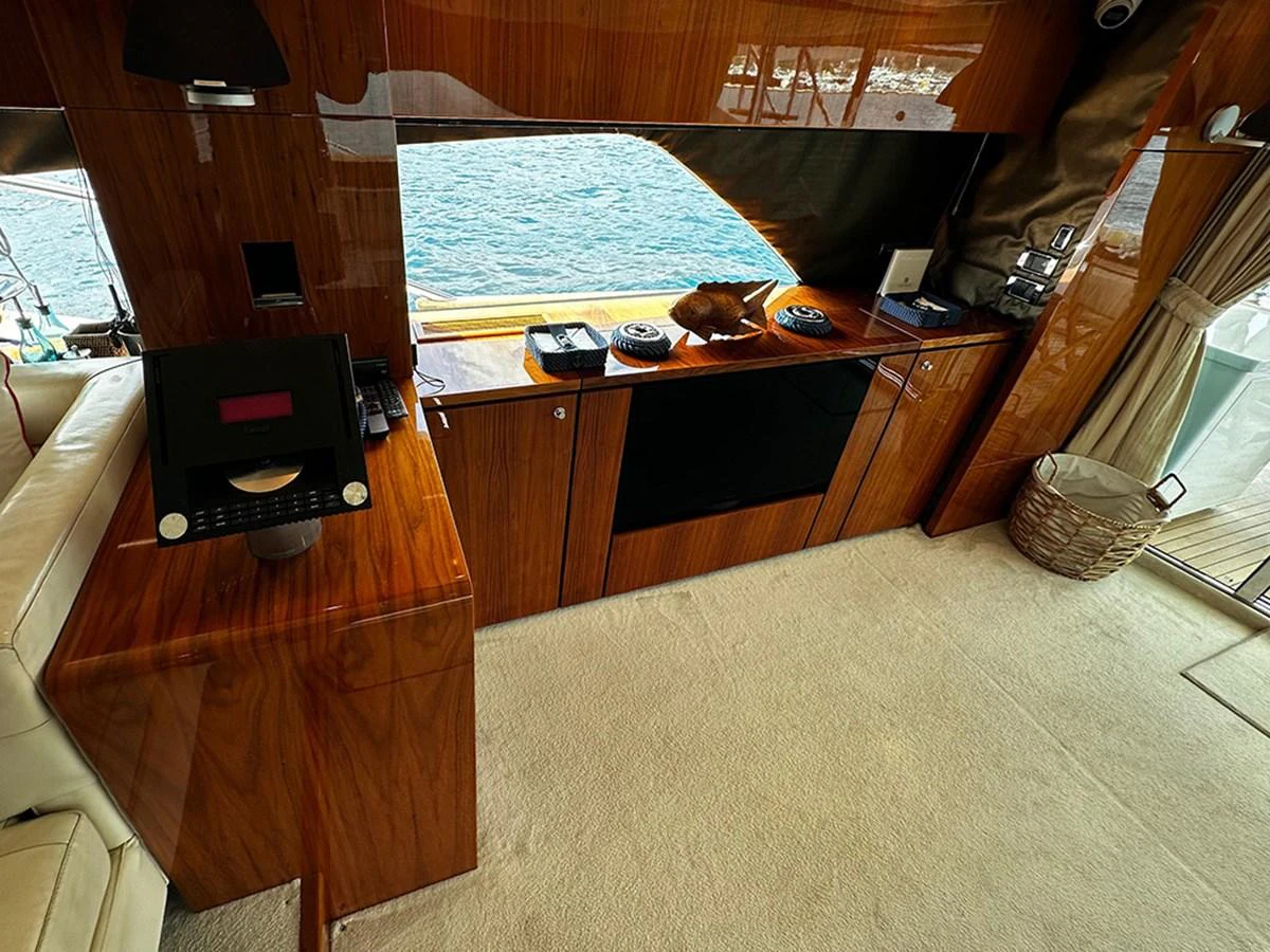 The interior features a polished wooden finish with a view of the water through large windows. aboard SEDEF Yacht for Sale