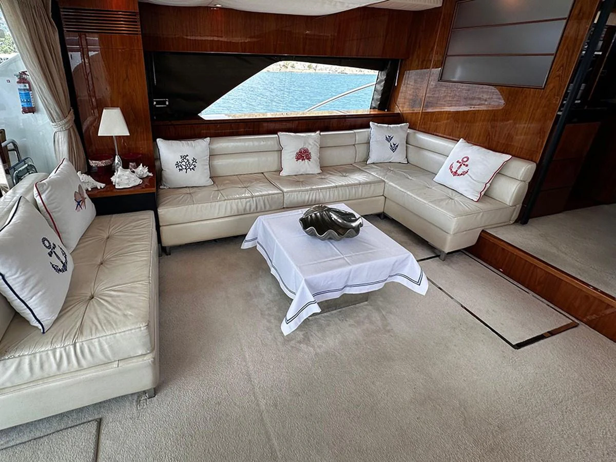 The salon features plush seating with nautical-themed cushions and a central coffee table, offering a cozy and elegant space for relaxation. aboard SEDEF Yacht for Sale