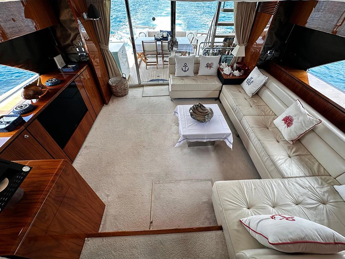 The salon features plush seating and elegant decor with a view of the aft deck and ocean beyond. aboard SEDEF Yacht for Sale