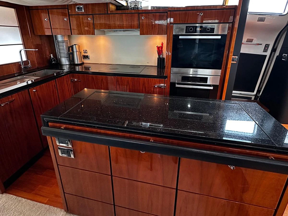 The yacht's galley features sleek wooden cabinetry and modern appliances, creating a sophisticated cooking space. aboard SEDEF Yacht for Sale