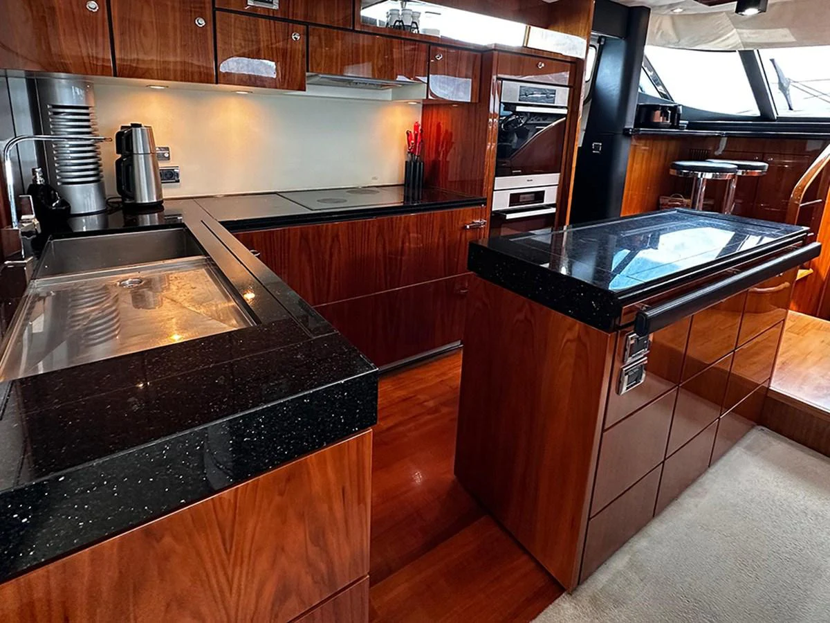 The yacht's galley features sleek wooden cabinetry and modern appliances, creating a sophisticated and functional space. aboard SEDEF Yacht for Sale
