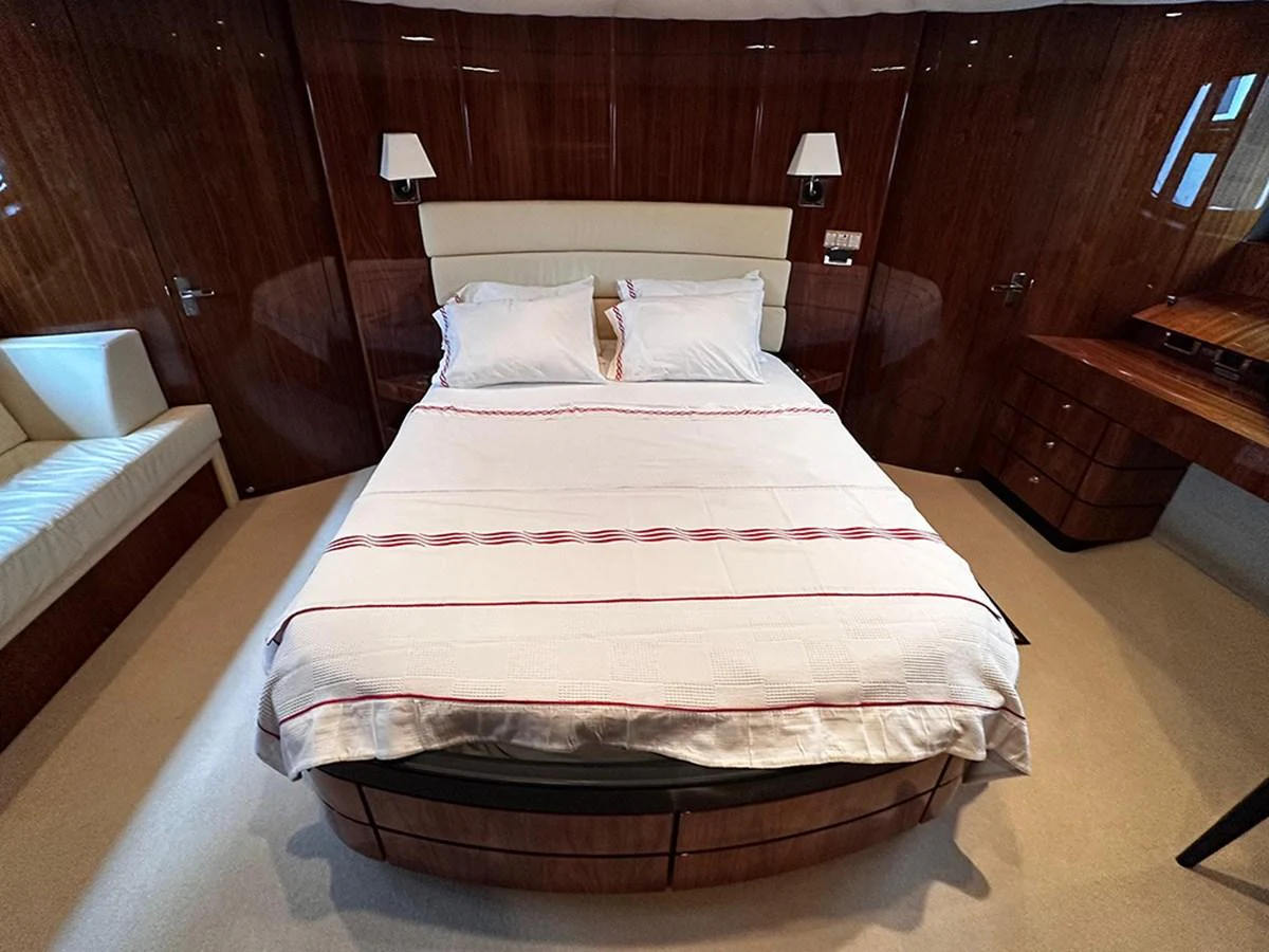 The stateroom features a luxurious bed with elegant wooden paneling and modern lighting. aboard SEDEF Yacht for Sale