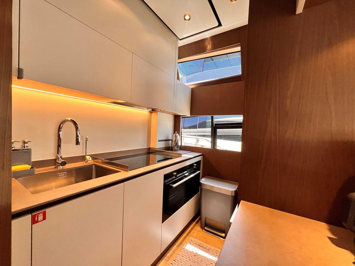The yacht's galley features modern appliances and sleek cabinetry, illuminated by warm lighting. aboard LD Yacht for Sale