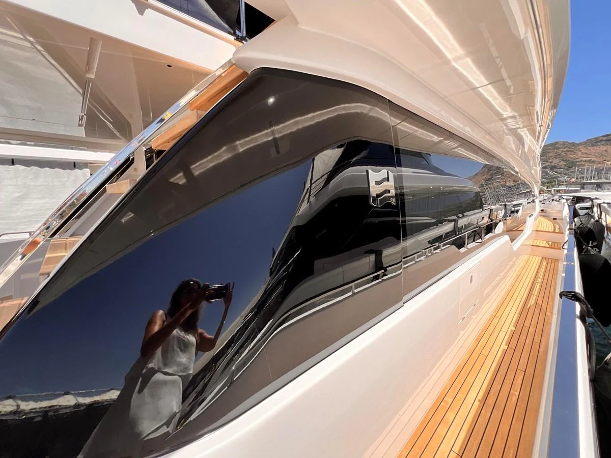 The image captures a sleek, reflective window detail along the yacht's deck. aboard LD Yacht for Sale