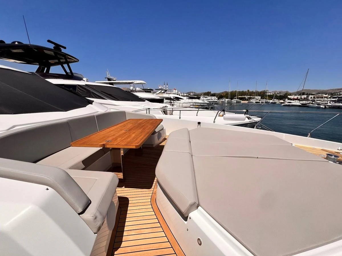 The foredeck features a comfortable seating area with a wooden table, perfect for enjoying the view while docked. aboard LD Yacht for Sale
