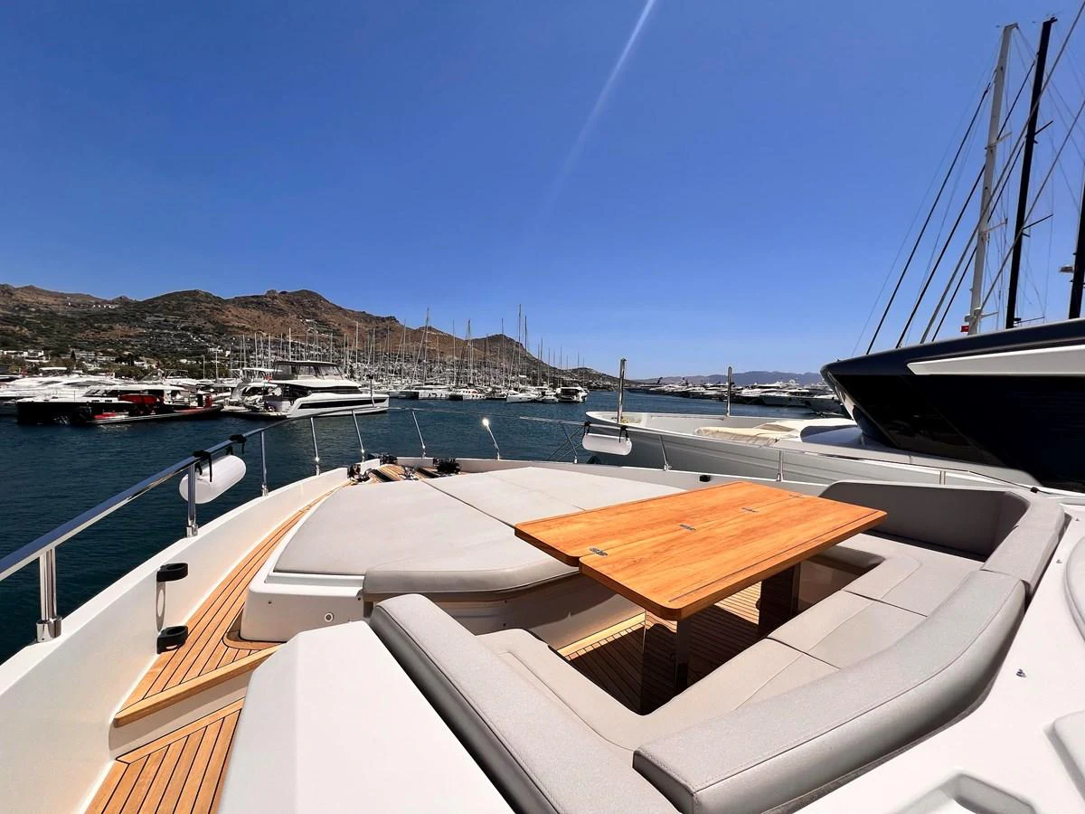 The yacht's foredeck features a spacious sunbathing area with a central wooden table, perfect for relaxation and socializing. aboard LD Yacht for Sale