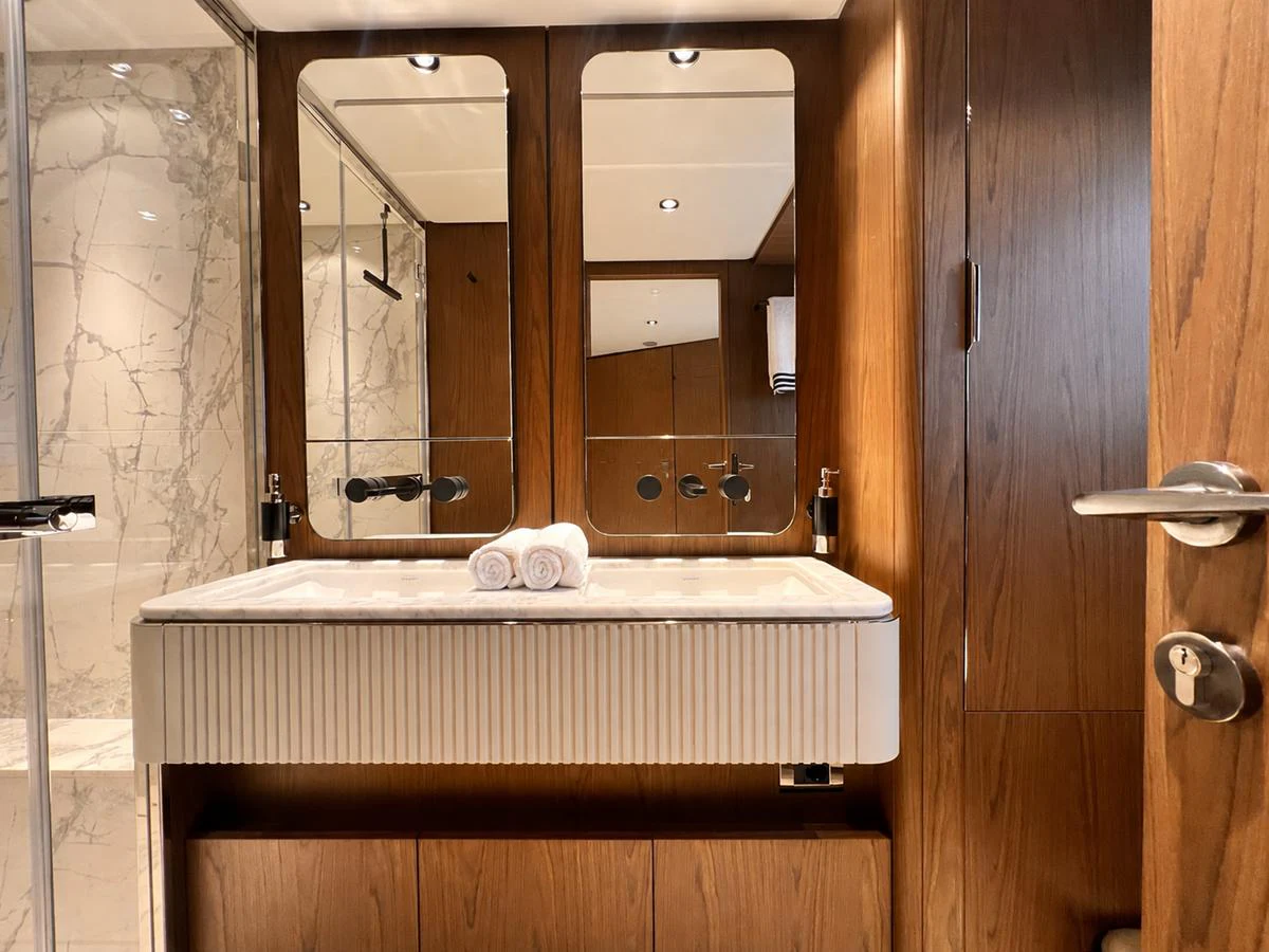 The yacht's bathroom features elegant wood paneling and a luxurious marble shower. aboard LD Yacht for Sale