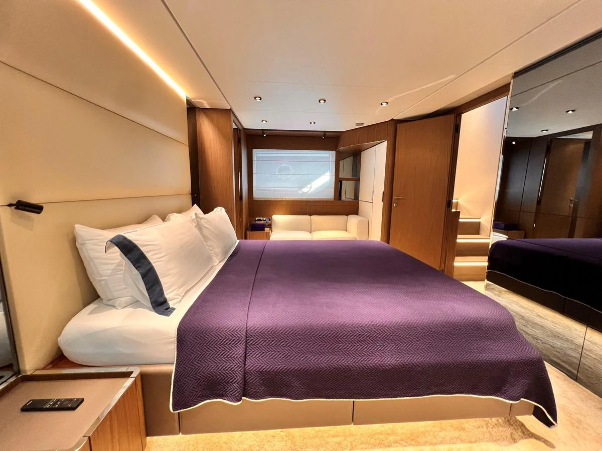 The master stateroom features a luxurious bed with plush bedding and modern wood finishes. aboard LD Yacht for Sale
