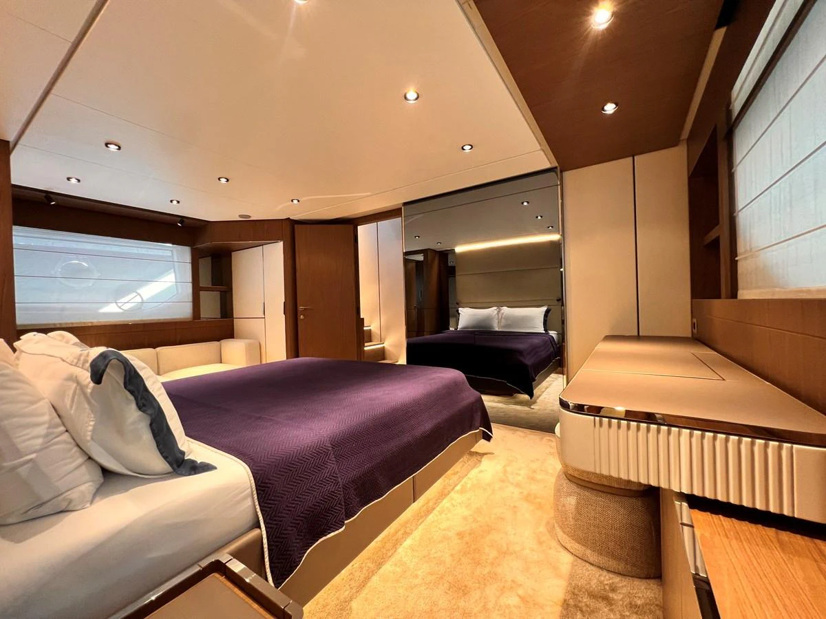 The master stateroom features a plush bed with elegant bedding, ample storage, and modern lighting. aboard LD Yacht for Sale
