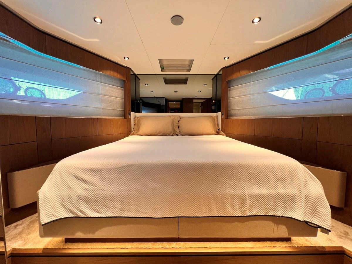 The master stateroom features a spacious bed with elegant lighting and wood accents. aboard LD Yacht for Sale