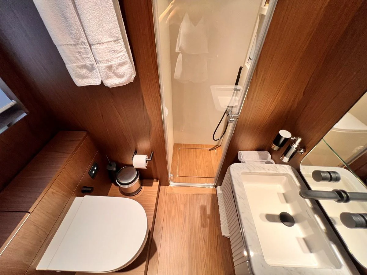 The yacht's bathroom features modern fixtures and a sleek design with warm wooden accents. aboard LD Yacht for Sale