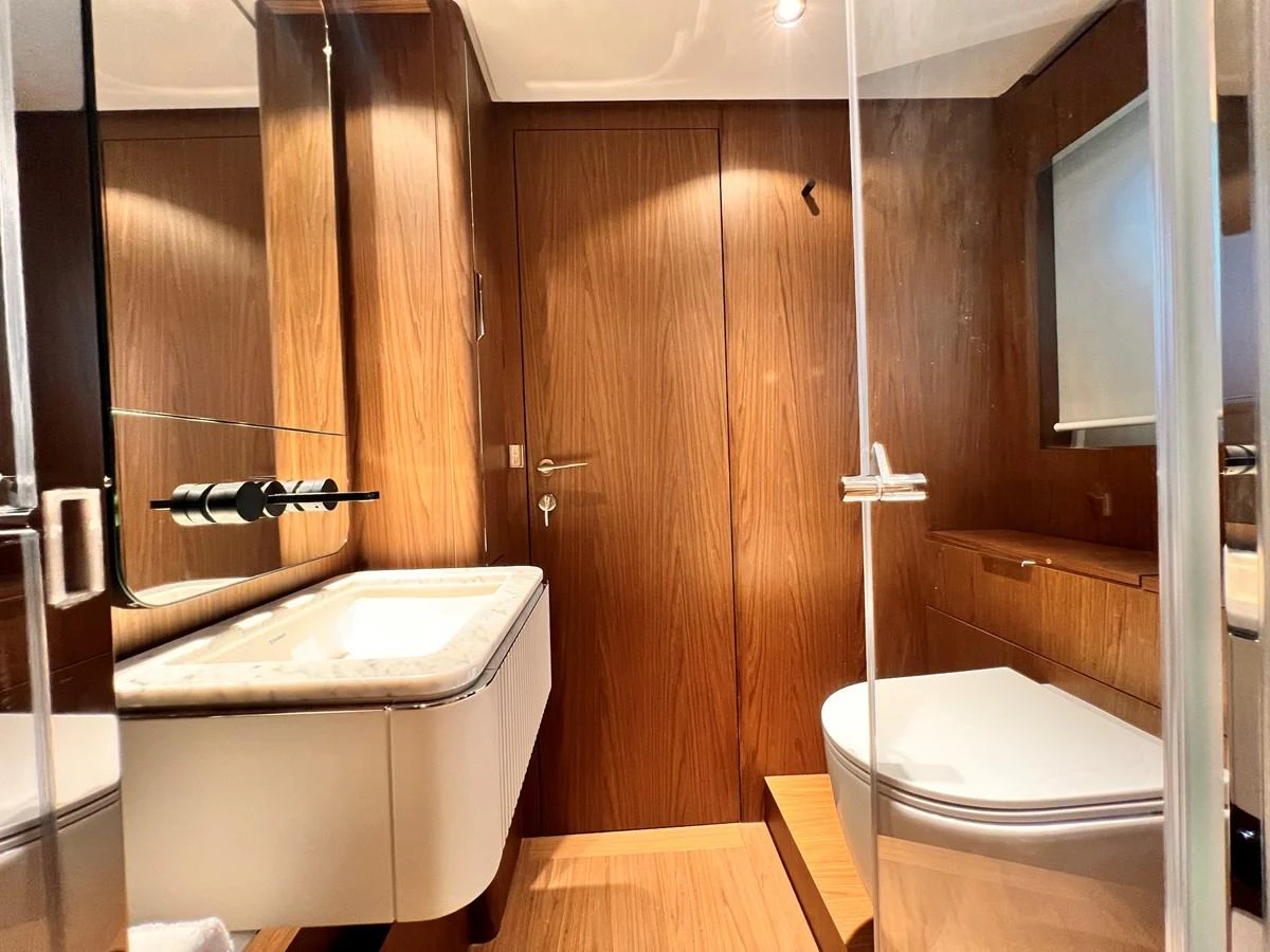 The yacht's bathroom features elegant wood paneling and modern fixtures. aboard LD Yacht for Sale