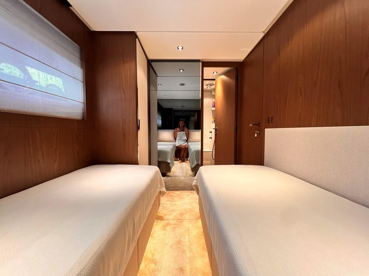 The guest cabin features twin beds with a modern, minimalist design and warm wooden accents. aboard LD Yacht for Sale