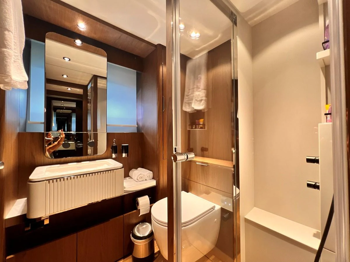 The yacht's bathroom features modern fixtures and a sleek design with warm wood accents. aboard LD Yacht for Sale