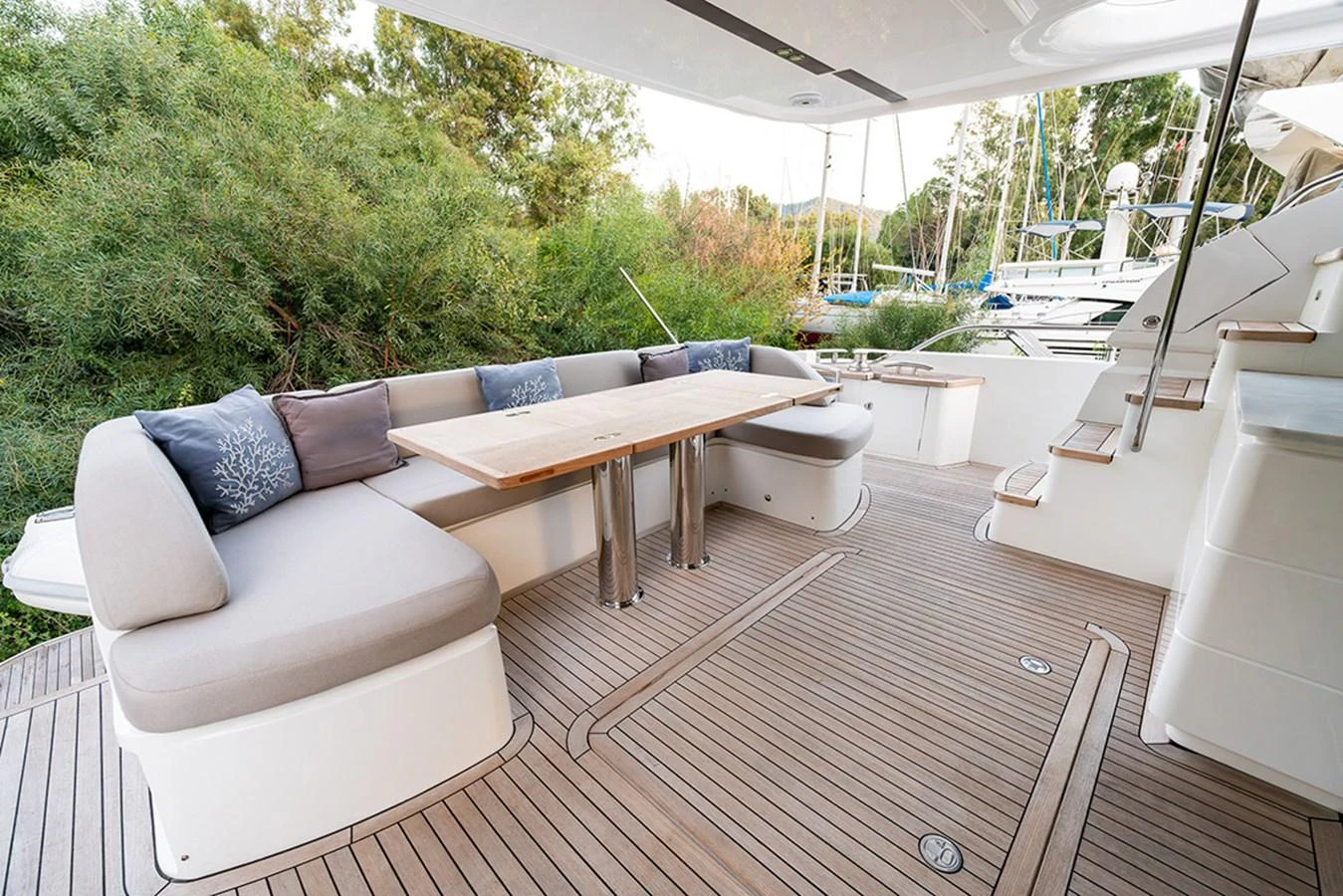 The aft deck features a spacious seating area with a wooden table, perfect for outdoor dining and relaxation. aboard DAPHNE Yacht for Sale