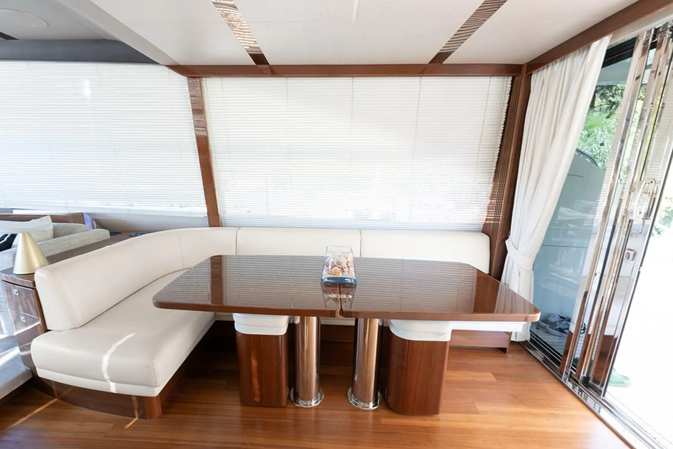The yacht's dining area features a sleek wooden table with comfortable seating and ample natural light. aboard DAPHNE Yacht for Sale