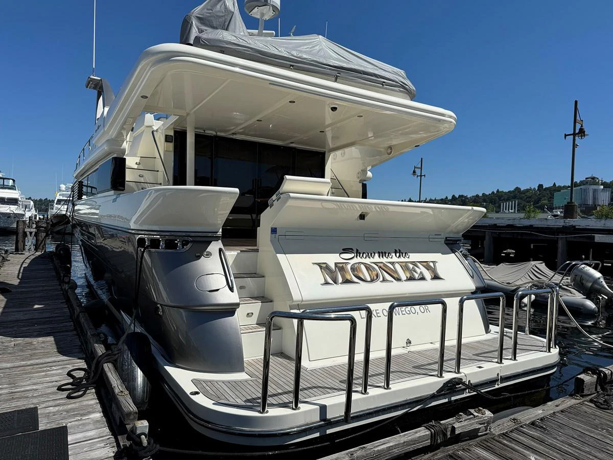 A luxurious yacht docked at a marina, showcasing its sleek design and spacious aft deck. aboard SHOW ME THE MONEY Yacht for Sale