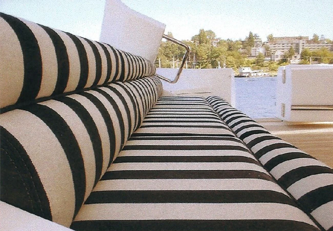 A stylish sunpad with black and white striped cushions offers a comfortable spot to relax and enjoy the view. aboard SHOW ME THE MONEY Yacht for Sale