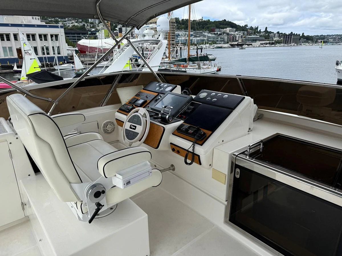 The helm station offers a commanding view with state-of-the-art navigation equipment and a comfortable captain's chair. aboard SHOW ME THE MONEY Yacht for Sale