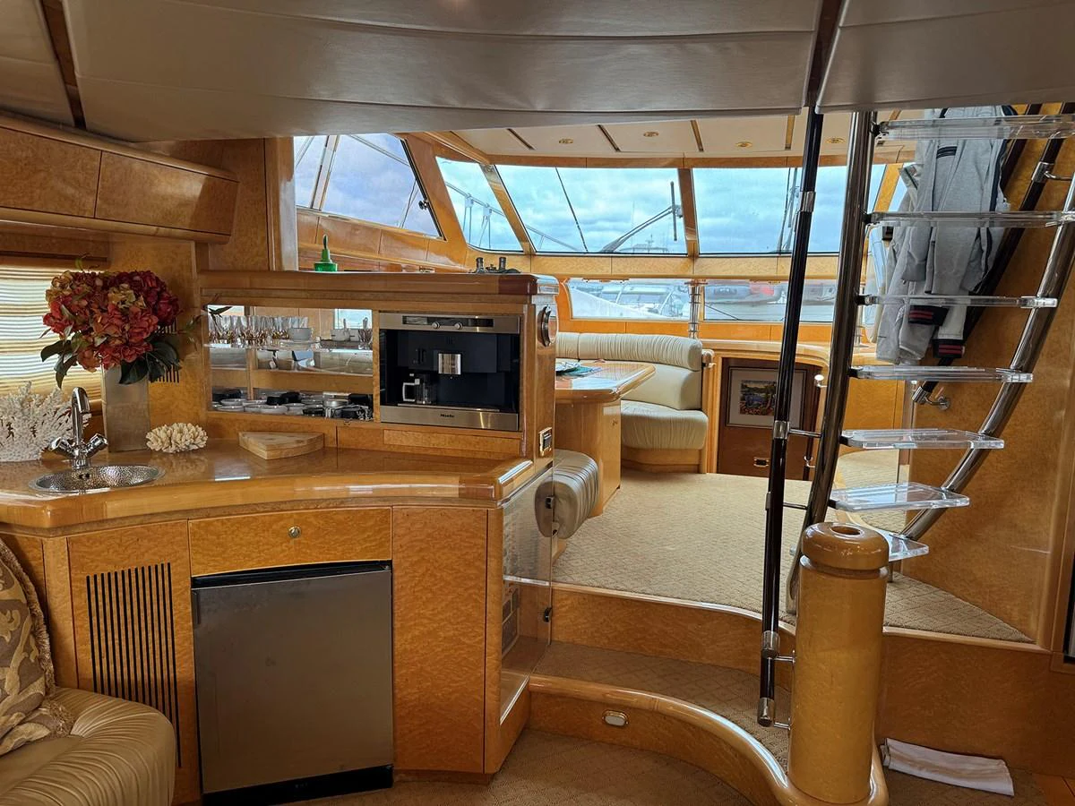 The yacht's salon features a cozy seating area, a well-equipped kitchenette, and a stylish staircase leading to the upper deck. aboard SHOW ME THE MONEY Yacht for Sale