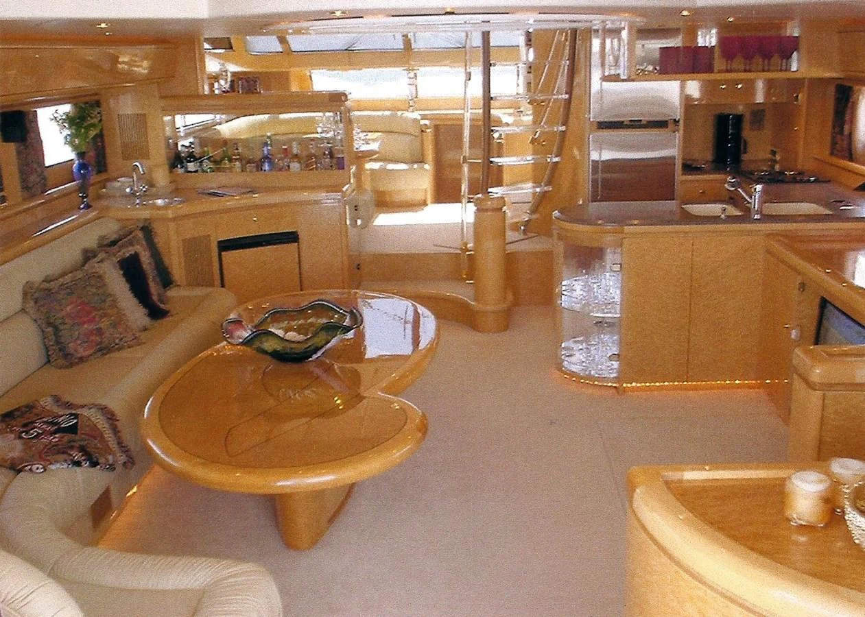 The salon features luxurious seating, a stylish coffee table, and a well-equipped galley area. aboard SHOW ME THE MONEY Yacht for Sale