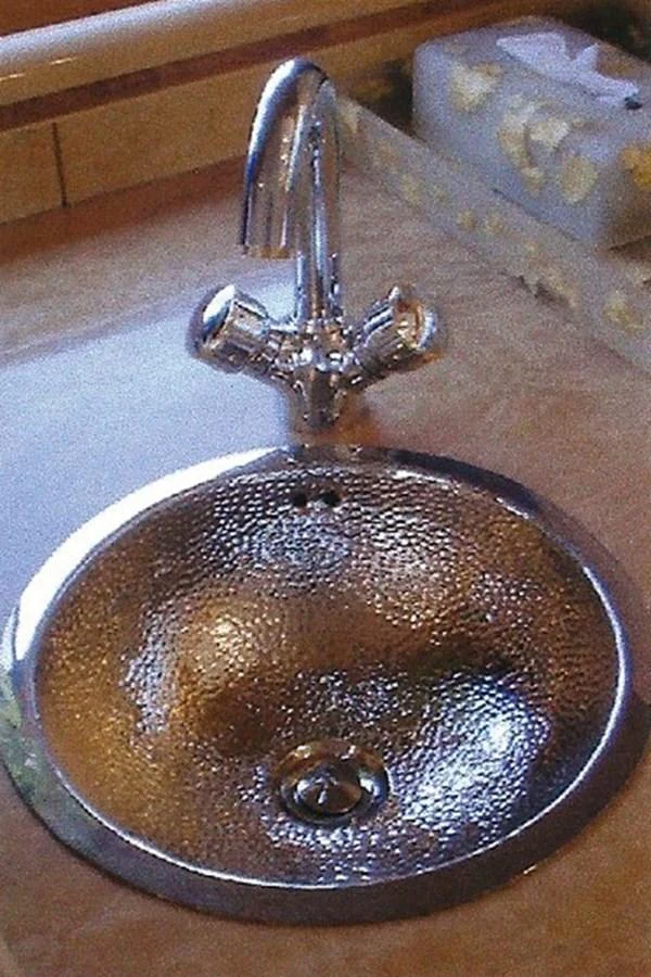 A polished metal sink with a modern faucet in a yacht's bathroom or galley. aboard SHOW ME THE MONEY Yacht for Sale
