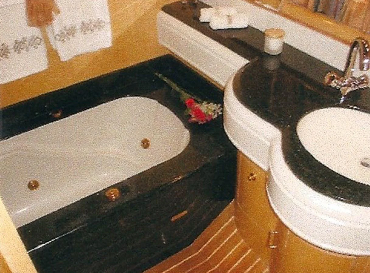 A luxurious bathroom featuring a bathtub and a stylish sink area. aboard SHOW ME THE MONEY Yacht for Sale