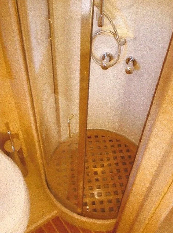 The yacht features a compact and functional shower area with a wooden grate floor and chrome fixtures. aboard SHOW ME THE MONEY Yacht for Sale