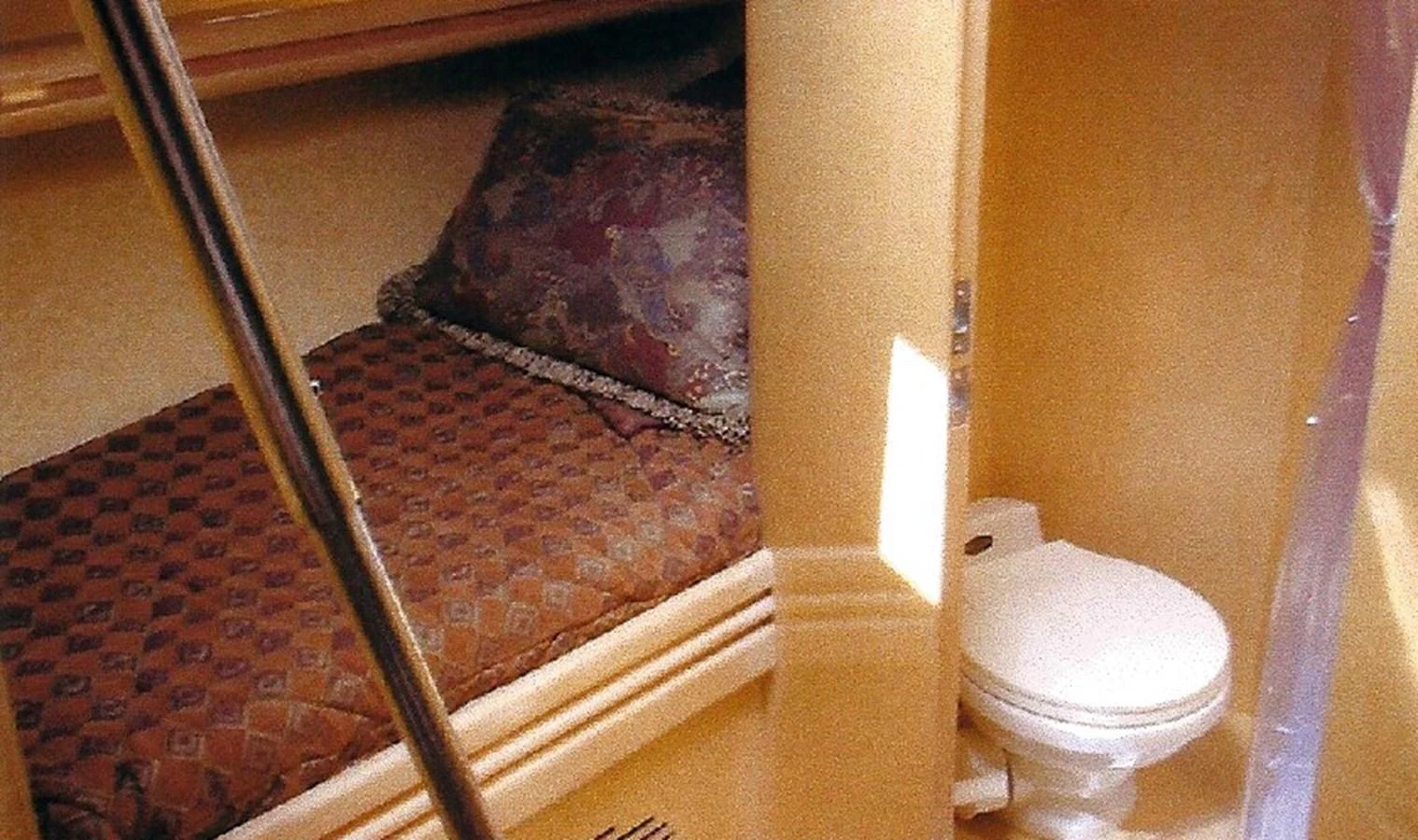 A cozy cabin featuring a comfortable bed and an adjacent private toilet. aboard SHOW ME THE MONEY Yacht for Sale