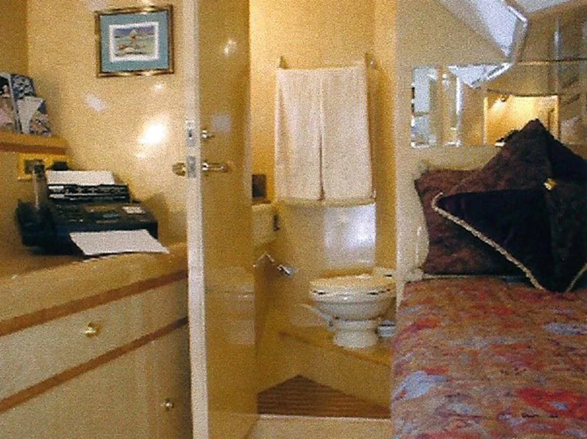 A cozy stateroom featuring a bed, a small desk area, and an en-suite bathroom. aboard SHOW ME THE MONEY Yacht for Sale