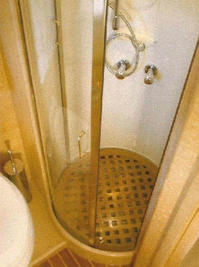 A compact and functional shower area with a glass door and wooden floor grating. aboard SHOW ME THE MONEY Yacht for Sale