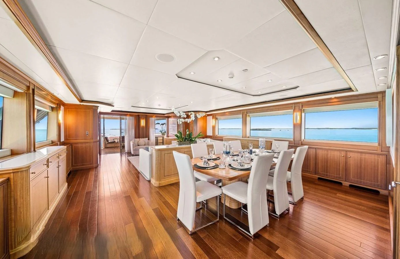 The yacht's dining area features elegant wooden flooring and large windows offering stunning ocean views. aboard BLACK SHEEP Yacht for Sale