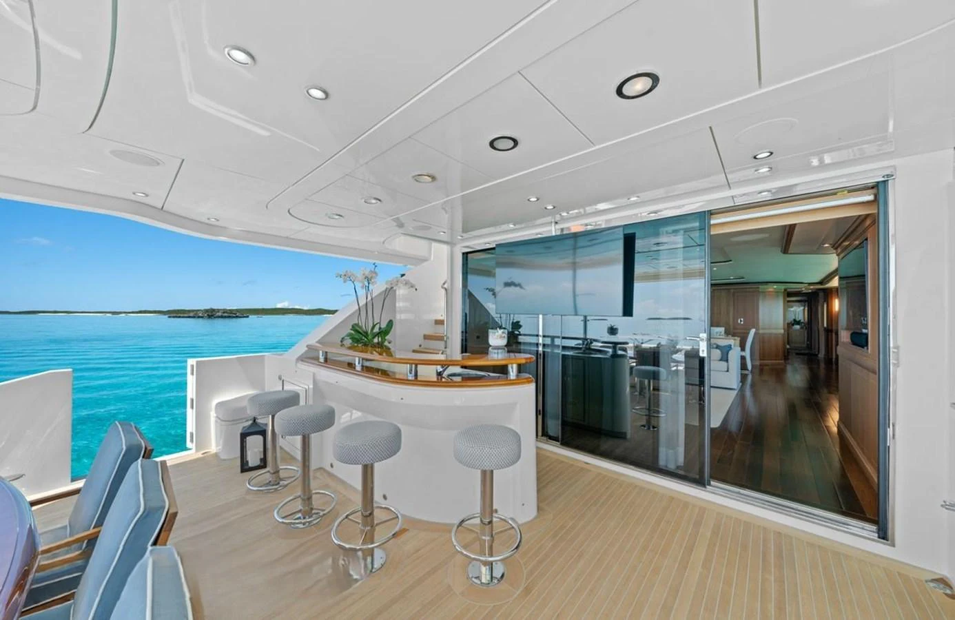 The aft deck features a stylish bar area with stools and a seamless transition to the interior living space. aboard BLACK SHEEP Yacht for Sale